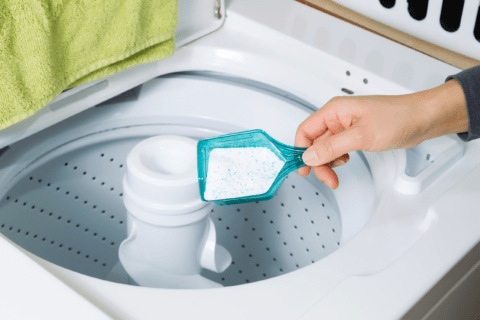 Adding washing detergent to washing machine.