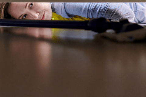 Woman cleaning under fridge using flat mop