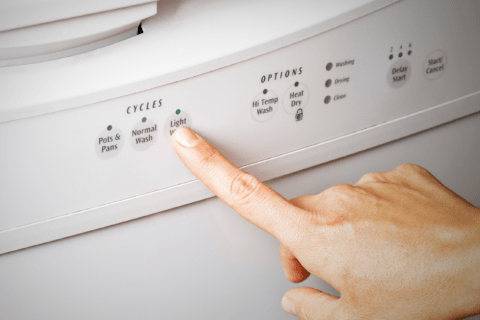 Pressing a dishwasher wash cycle button.