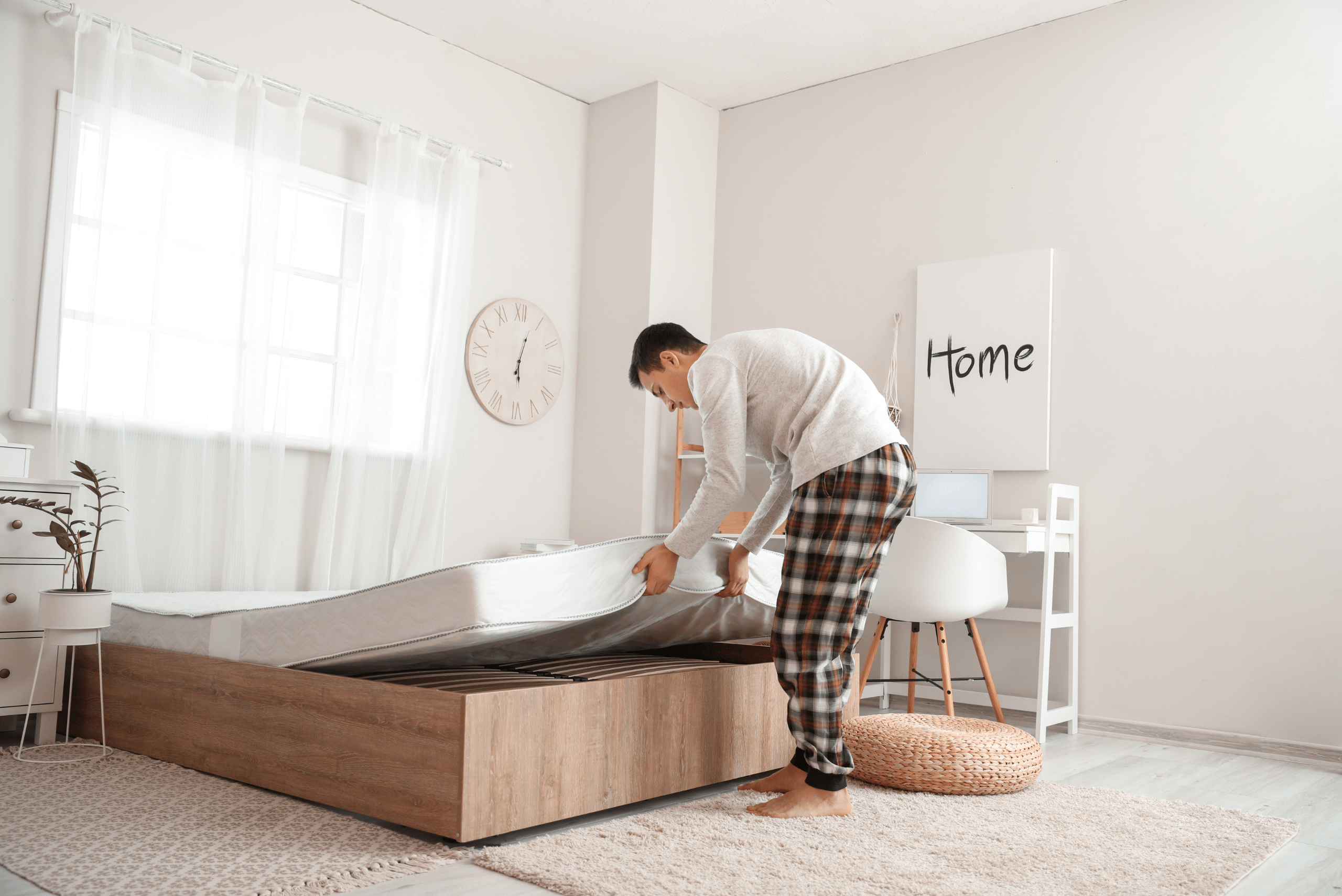 Man flipping mattress on a bed.