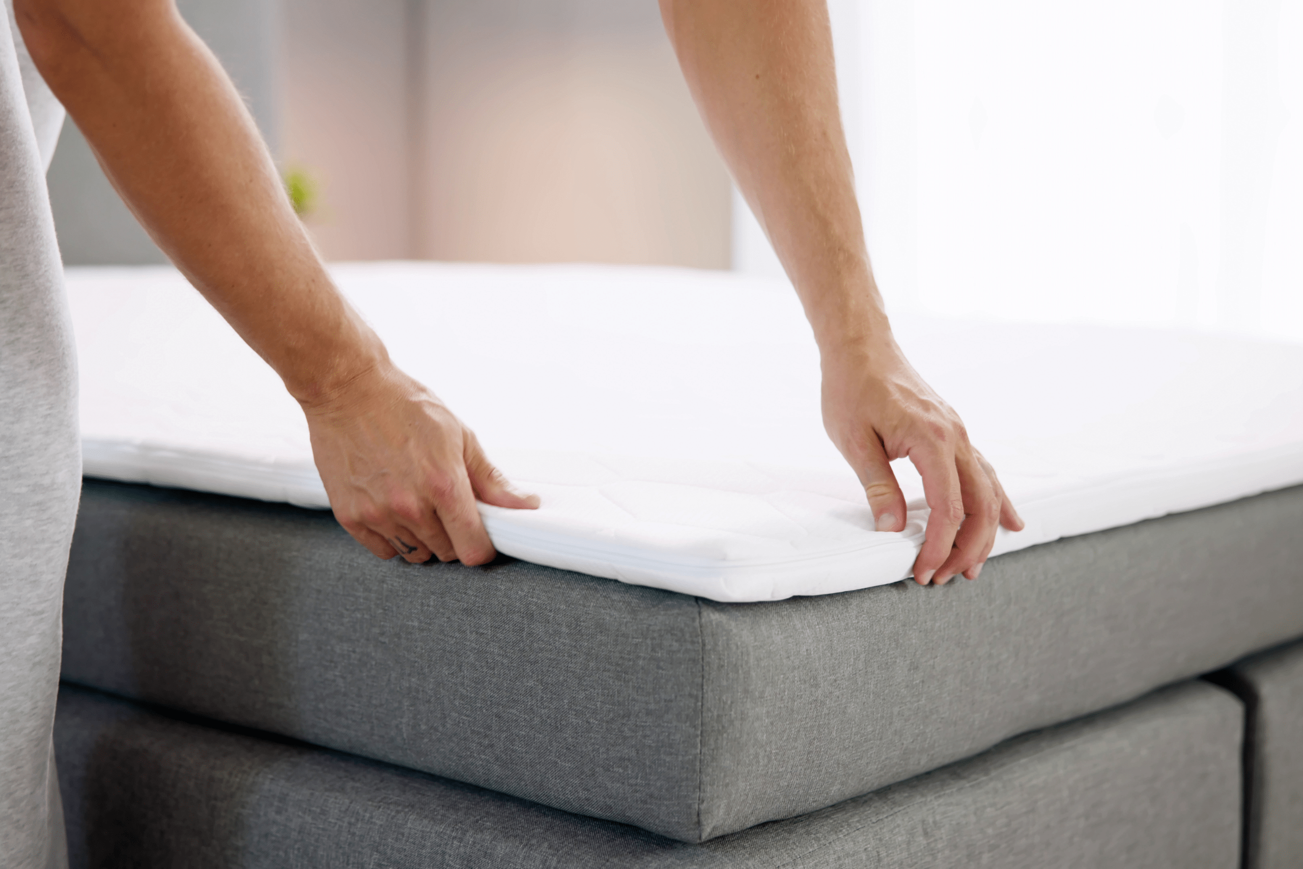 Person putting on a mattress topper.